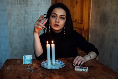 Falcı, bir mum alevine bakar. Geleceği görmek için büyülü bir ayin.