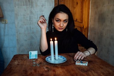 Falcı, bir mum alevine bakar. Geleceği görmek için büyülü bir ayin.