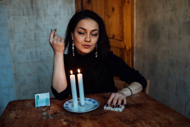 Falcı, bir mum alevine bakar. Geleceği görmek için büyülü bir ayin.