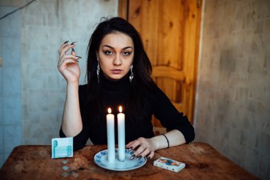 Falcı, bir mum alevine bakar. Geleceği görmek için büyülü bir ayin.