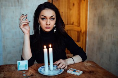 Falcı, bir mum alevine bakar. Geleceği görmek için büyülü bir ayin.