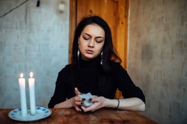 Falcı geleceği tahmin etmek için kartları karıştırıyor.