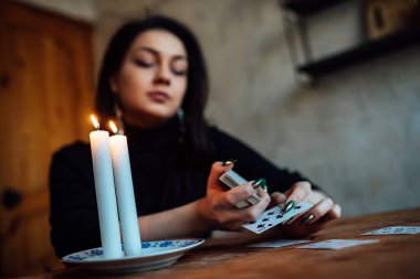 Falcı geleceği tahmin etmek için kartları karıştırıyor.