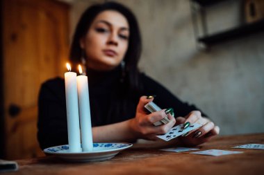 Falcı geleceği tahmin etmek için kartları karıştırıyor.