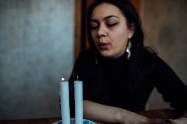 Geleceği tahmin eden bir seanstan sonra falcı ayin mumlarını üfler.