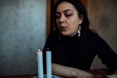 Geleceği tahmin eden bir seanstan sonra falcı ayin mumlarını üfler.