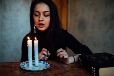 Geleceği tahmin eden bir seanstan sonra falcı ayin mumlarını üfler.