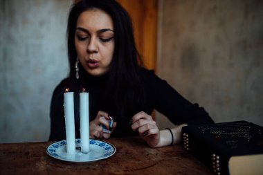 Geleceği tahmin eden bir seanstan sonra falcı ayin mumlarını üfler.