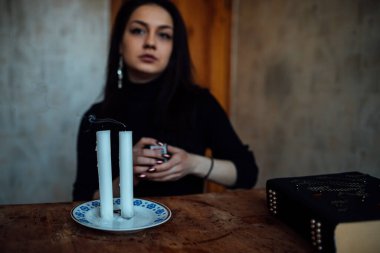 Geleceği tahmin eden bir seanstan sonra falcı ayin mumlarını üfler.