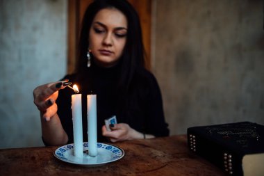 Geleceği tahmin eden bir seanstan sonra falcı ayin mumlarını üfler.