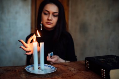 Geleceği tahmin eden bir seanstan sonra falcı ayin mumlarını üfler.