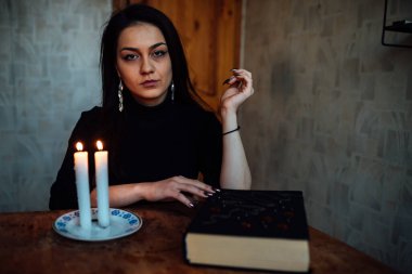 Kız, yanan bir mum ve kartlarla geleceği ve kaderi tahmin ediyor.