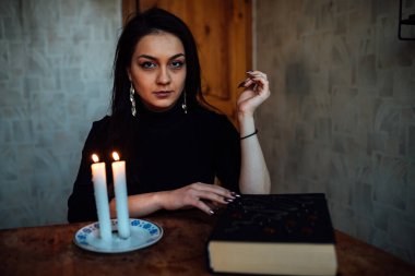 Kız, yanan bir mum ve kartlarla geleceği ve kaderi tahmin ediyor.