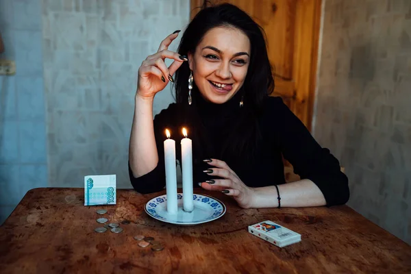 Falcı, bir mum alevine bakar. Geleceği görmek için büyülü bir ayin.