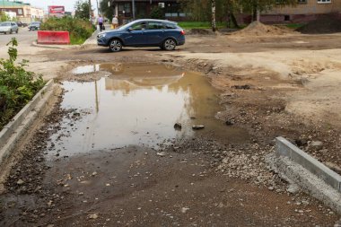 Kazılı yol. Şehirdeki yol ekipmanlarıyla caddenin tamiri. Yeni asfalt döşeme ve iletişimin değiştirilmesi