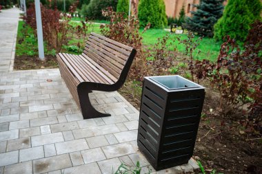 Yaz parkında ahşap bir bank. Doğanın arka planında oturmak için rahat bir yer.