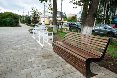 Yaz parkında ahşap bir bank. Doğanın arka planında oturmak için rahat bir yer.