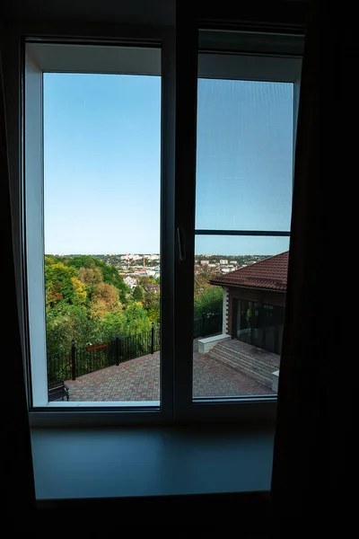 view from the hotel window on the green city. landscape outside the window on a summer day