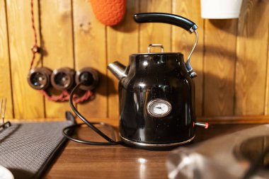 Mutfak masasında retro elektrikli su ısıtıcısı duruyor. Çay demle, su kaynat.
