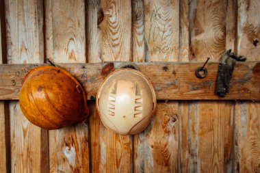 İnşaat miğferleri duvara asılı. Tehlikeli üretimlerde kafa koruması. işçi üniformaları.