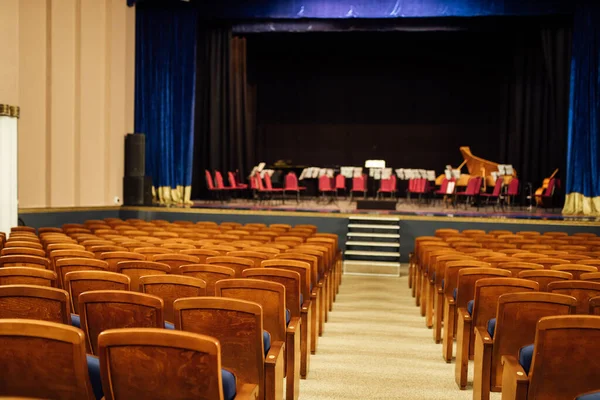 an empty concert hall. rows of seats unoccupied by the audience. on the stage are musical instruments waiting for the orchestra. music hall before the concert