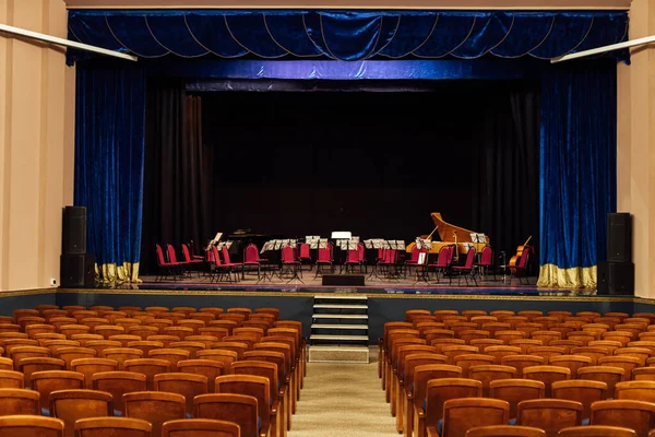 an empty concert hall. rows of seats unoccupied by the audience. on the stage are musical instruments waiting for the orchestra. music hall before the concert