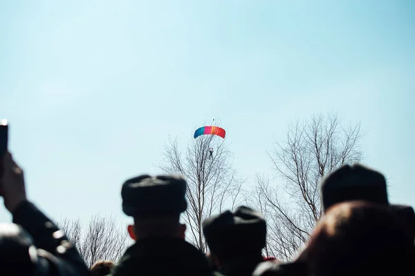 观众在着陆伞兵背景下的轮廓 跳伞运动员从高空从飞机上跳下的演示表演 极限运动节 — 图库照片