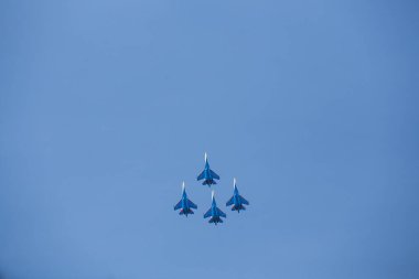 Dört jet uçağı sıkı bir düzende uçuyor. Pilotlar, havacılık festivalinde tehlikeli akrobatik hareketleri gösteriyor. Modern savaş uçaklarının askeri geçit töreni
