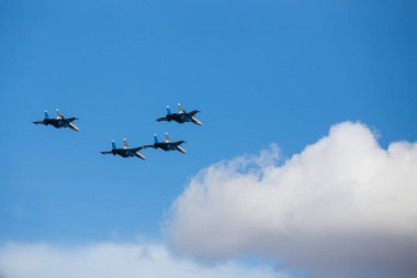 Dört jet uçağı sıkı bir düzende uçuyor. Pilotlar, havacılık festivalinde tehlikeli akrobatik hareketleri gösteriyor. Modern savaş uçaklarının askeri geçit töreni