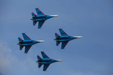 Dört jet uçağı sıkı bir düzende uçuyor. Pilotlar, havacılık festivalinde tehlikeli akrobatik hareketleri gösteriyor. Modern savaş uçaklarının askeri geçit töreni