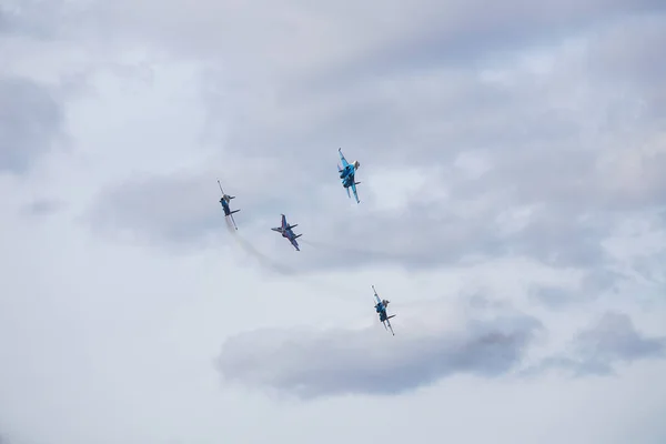 Dört jet uçağı sıkı bir düzende uçuyor. Pilotlar, havacılık festivalinde tehlikeli akrobatik hareketleri gösteriyor. Modern savaş uçaklarının askeri geçit töreni