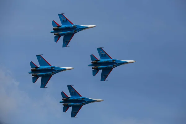 Dört jet uçağı sıkı bir düzende uçuyor. Pilotlar, havacılık festivalinde tehlikeli akrobatik hareketleri gösteriyor. Modern savaş uçaklarının askeri geçit töreni