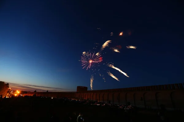 independence day and carnival festival in city, colourful enchanting spectacle of colored flashes of fireworks fills sky on background of old city wall, a bright celebration for many tourists