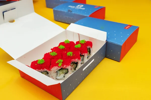 寿司ロールとフレッシュジュースのボトル付きのオープンボックス 環境に優しい材料で作られた食品配達パッケージ 明るい色の美しい使い捨て食器 — ストック写真