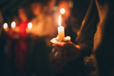 Bir kız elinde yanan bir mum, dini bir gelenek, Hıristiyan inancının bir sembolü, bir mum yanan bir mum, sönmüş bir fitilden çıkan bir duman, sönmüş bir mum,