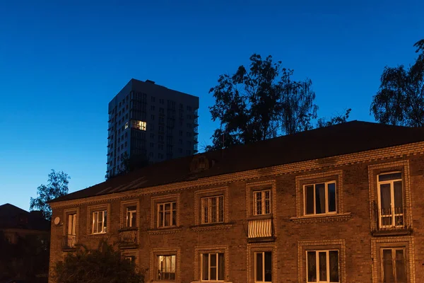 Çok katlı bir apartmanın çok katlı penceresinin birinde ışık yanıyor.