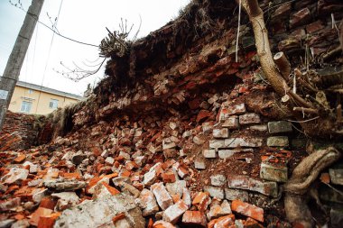 Bir patlamayla yıkılan tuğla bir duvar. Savaş tarihi binaları yıkıyor. Bir ev çökmüştü. Eski kalenin kalıntıları yerde yatıyordu.