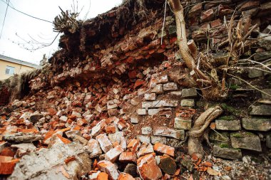 Bir patlamayla yıkılan tuğla bir duvar. Savaş tarihi binaları yıkıyor. Bir ev çökmüştü. Eski kalenin kalıntıları yerde yatıyordu.