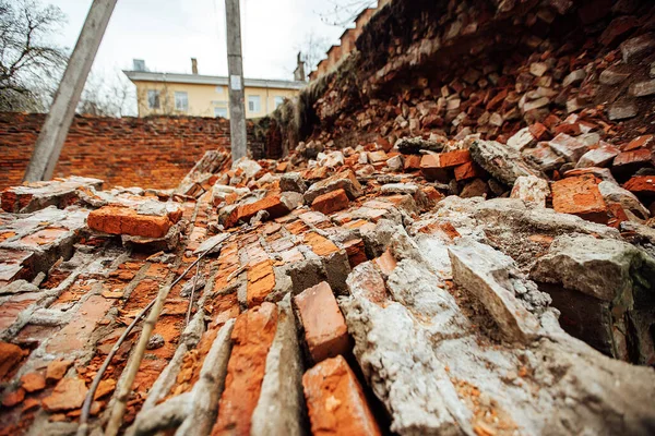a brick wall destroyed by an explosion. the war destroys historical buildings. there was a house collapse. the ruins of the old fortress lie on the ground