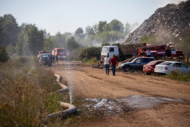 Bir kamyon çöplüğe tonlarca çöp atıyor. Zararlı atık sahalarında zehirli duman ve sis. Çevresel bir felaket. Çöplükte yanan çöpler.