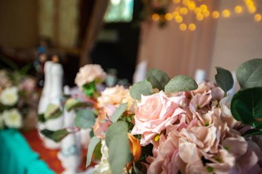 Gelin ve damat bir düğün buketi tutuyorlar. Düğün töreninde çok güzel süslenmiş çiçekler. Aile tatili dekorasyonu