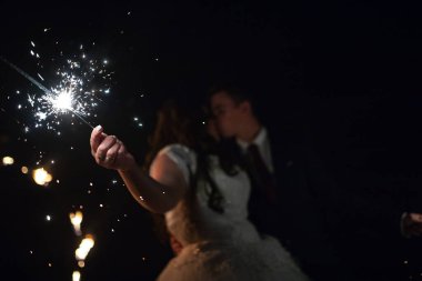 Aşıklar ellerinde yanan maytaplar tutarlar. Havai fişekten kıvılcımlar öpüşen gelin ve damadı aydınlatır. Düğünün akşam tamamlanması.