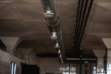 Depodaki havalandırma boruları. Endüstriyel tesislerde temiz hava dolaşımı için iletişim. Beyaz metal borular tavanın altına gerilmiş. Havalandırma ve soğutma sistemi