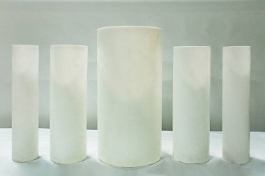 Farklı çaplarda siyah silindirik plastik borular stokta. Boru tesislerinin ürünlerinin sergilenen örnekleri. Yeraltı hizmetleri için polimer borular