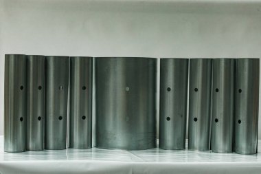 Farklı çaplarda siyah silindirik plastik borular stokta. Boru tesislerinin ürünlerinin sergilenen örnekleri. Yeraltı hizmetleri için polimer borular