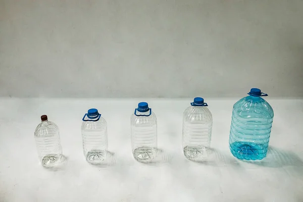 Несколько Пустых Пластиковых Бутылок Разного Размера Стоят Белом Фоне Одноразовые — стоковое фото