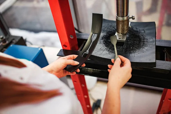 a worker with an industrial press. hold the workpiece in your hands for the part to work under high pressure. automated production machine operator