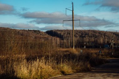 Sonbahar endüstriyel manzarası. Yaprak dökümü döneminde orman ve terk edilmiş sanayi binaları. Banliyödeki elektrik hatları. Eski fabrikanın atölyeleri