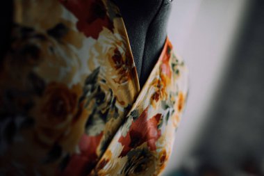 Manken üzerindeki doğal kumaştan yapılmış sarı-kırmızı bir elbisenin tasması. Kıyafetlerin yakın plan fotoğrafı. pürüzsüz dikişler ve dikişler iplikle dikilmiş. Terzi evde özel terzilik yapıyor..