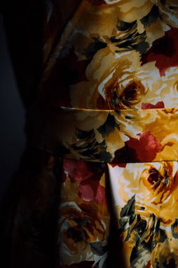 Doğal kumaştan yapılmış ve mankenin üzerindeki çiçek desenli bir elbise. Terzi evde özel terzilik yapıyor. Aydınlatıcı elbisenin güzel dikişleri yakın plan